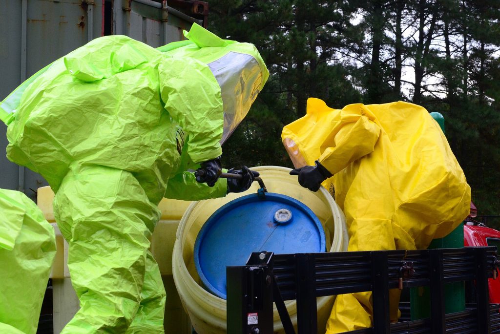 Firefighters putting on protective suits during a hazardous materials training exercise