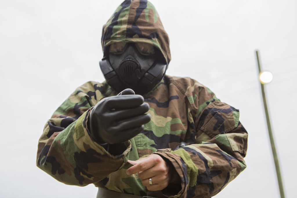 Responder fitting a protective mask during CBRN decontamination training