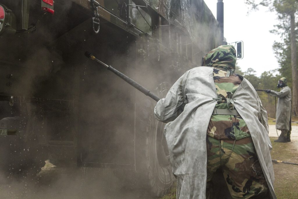 Responders spraying decontamination solution during a CBRN training exercise